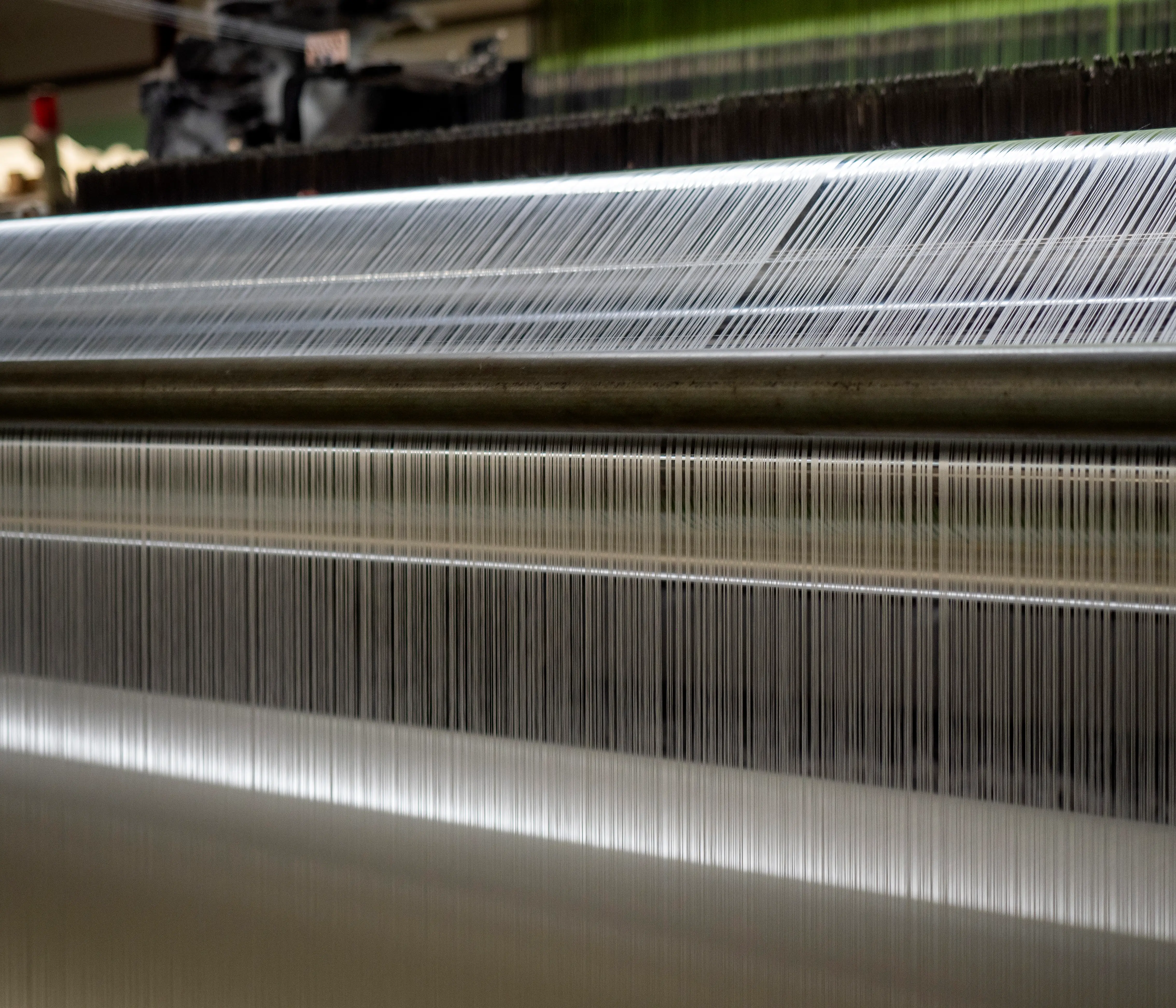 Artisan hands inspecting a bolt of fabric at the quality control table